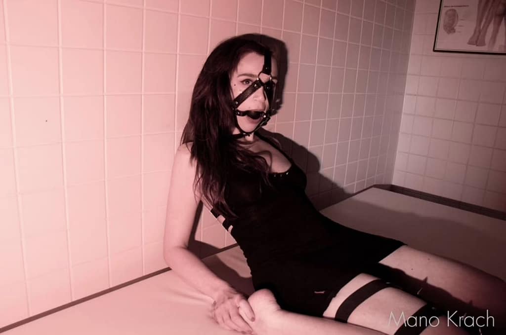 Female Studio Slave Usagi from Berlin wearing a BDSM head harness in a studio setting.