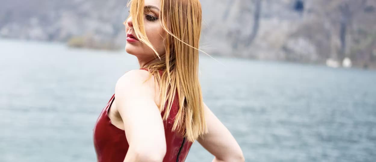 Mistress Lady Nadine from Zurich in a red latex dress by a lake.