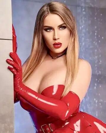 Mistress Jenna Rose, a German Bizarre Dominatrix, wearing a glossy red latex outfit and long red gloves