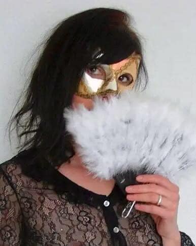 Miss M mit Maske und Federfächer in einem BDSM-Porträt