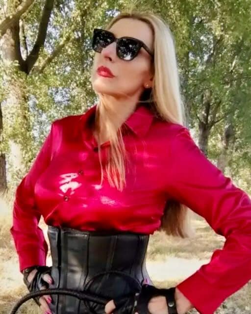 Dada Sreni, Milan-based Italian Dominatrix, wearing a red blouse and black corset outdoors.