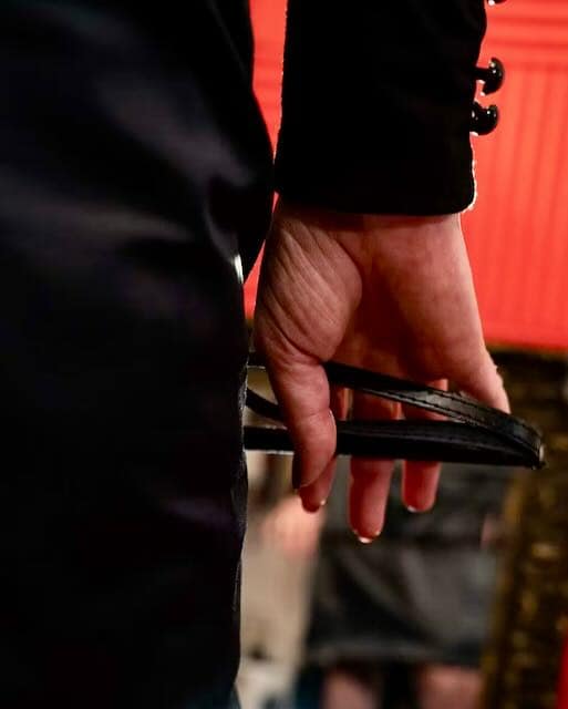 Dominatrix Saylie, Paris Pro-Mistress and Femdom author holding a BDSM paddle