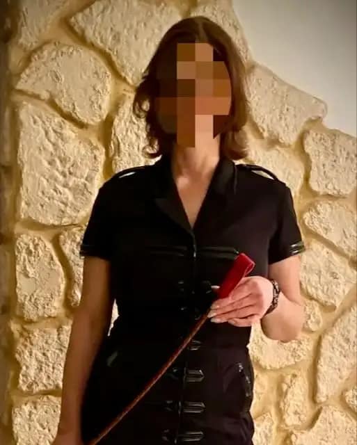 Private Eheherrin Sandra in schwarzem Outfit mit Reitgerte in einer FLR-Ehe