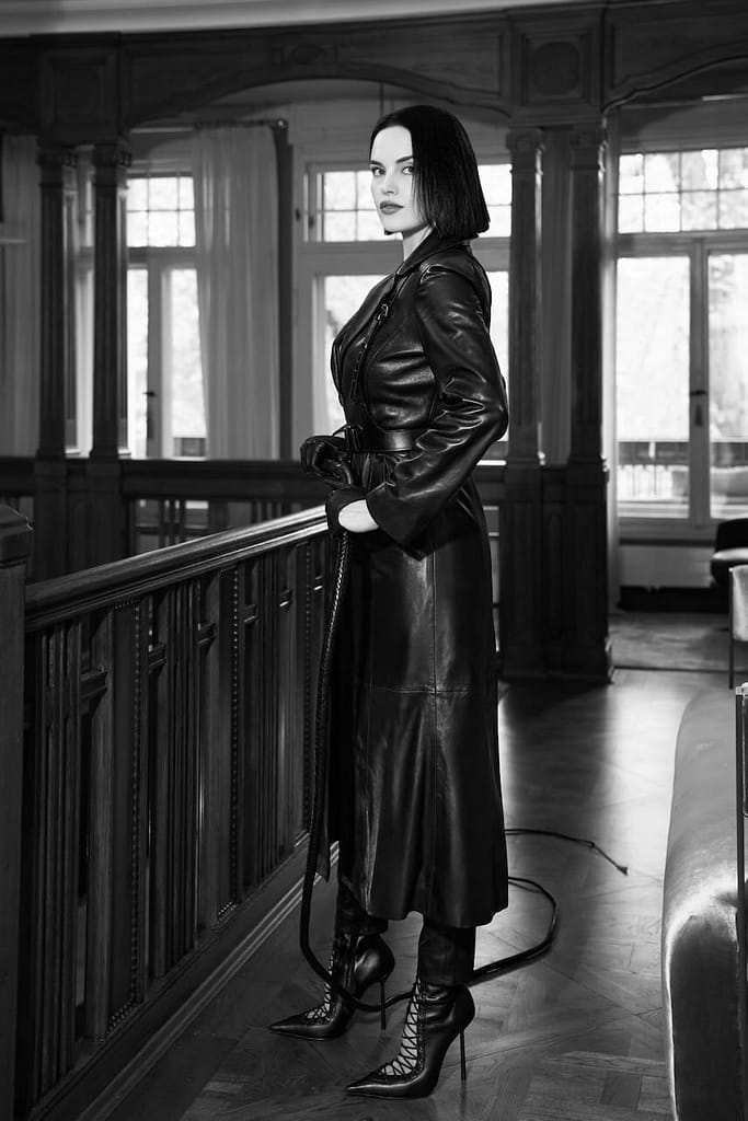 Mistress Deva Venera in Paris wearing a long black leather coat and holding a whip