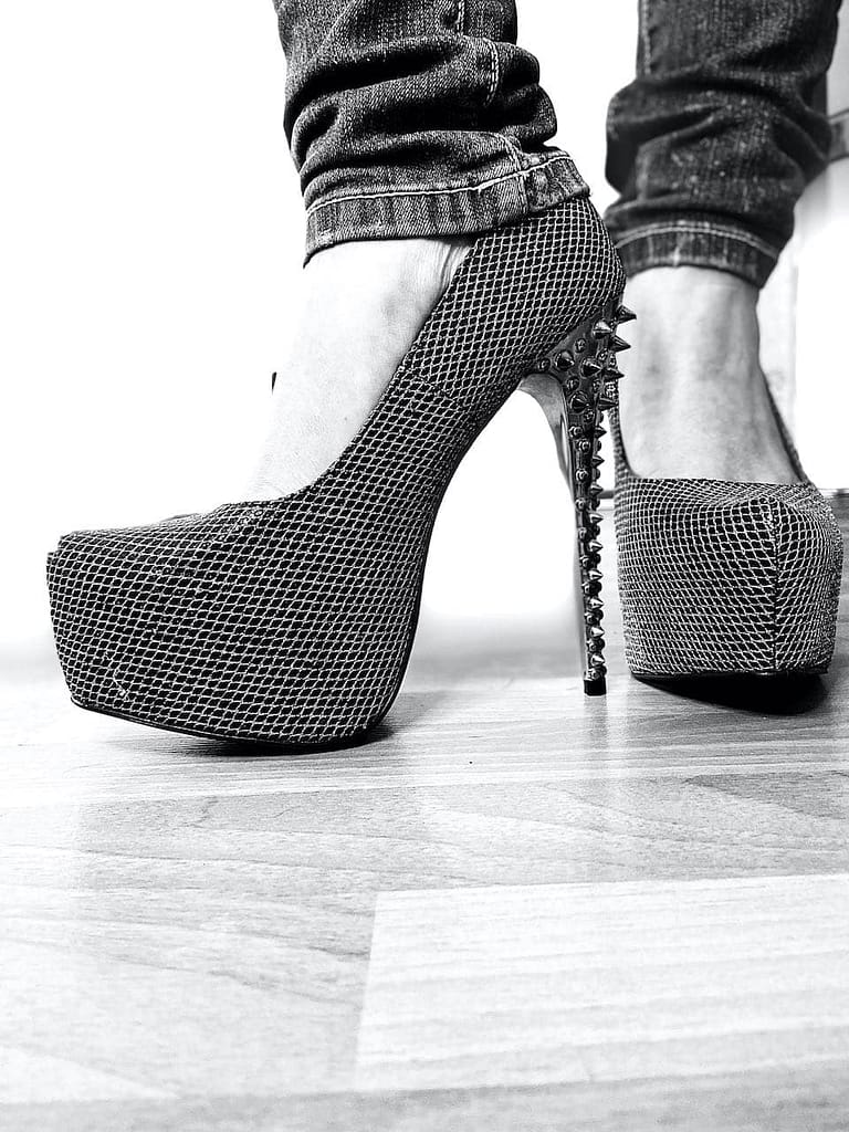 Real femdom close-up of high platform heels with a spiked stiletto heel, photographed in black and white