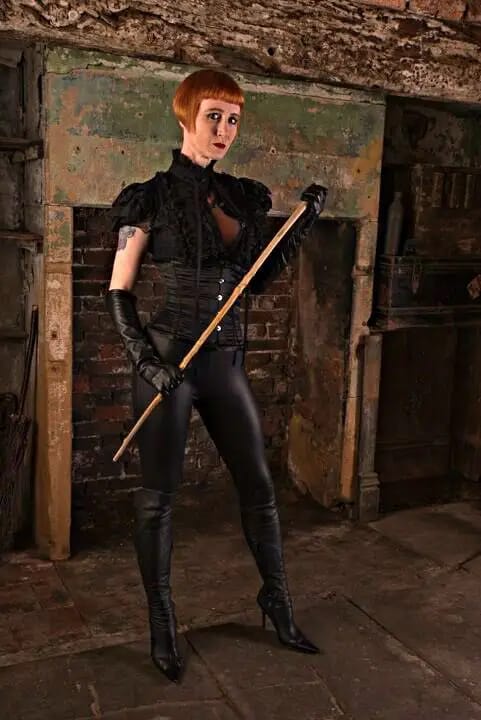 Dominatrix Liza, UK, wearing a black Fetish-Outfit.
