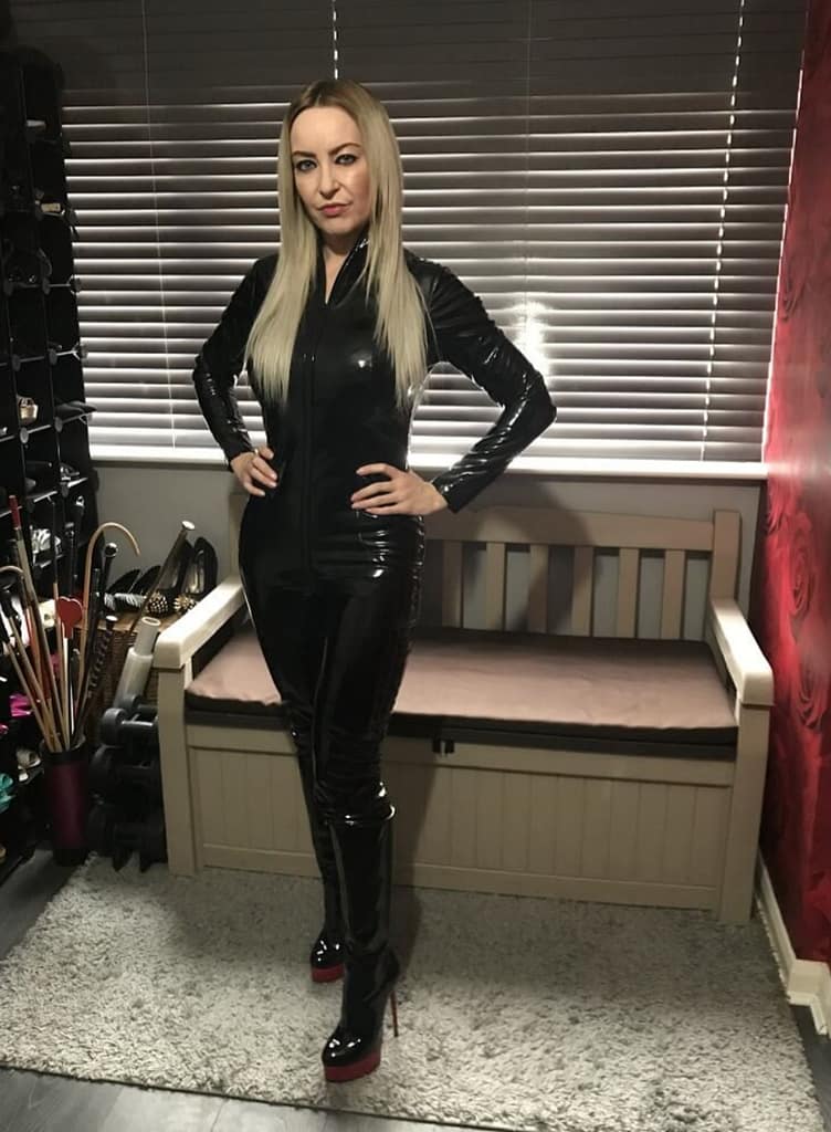 Miss Jessica Wood, professional Mistress from Hertfordshire, UK, wearing a black latex-style catsuit in a BDSM setting
